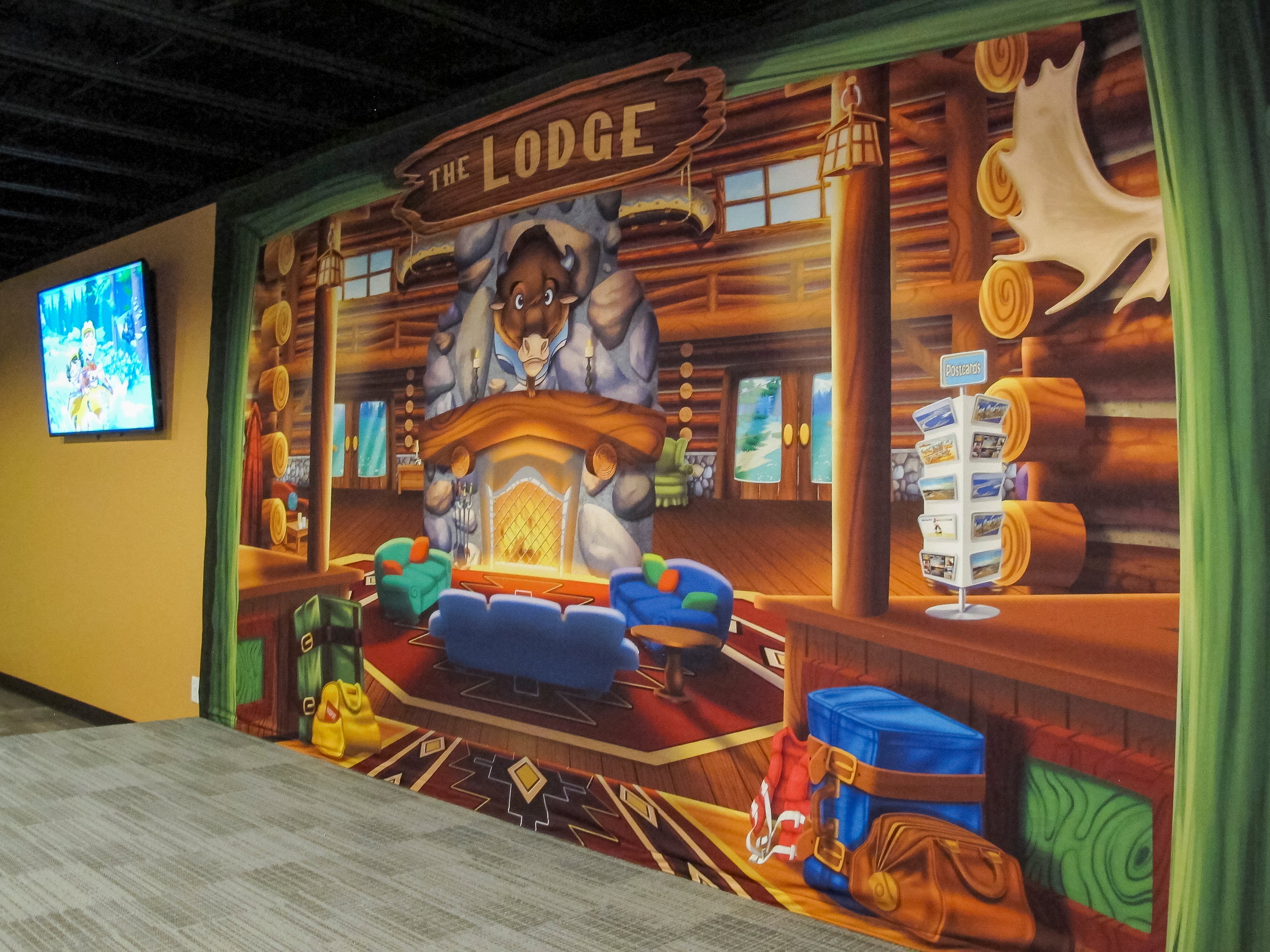 Custom lodge-themed mural creates the illusion of looking into a rustic mountain lodge in Faith Community Church's FaithKids children's ministry.