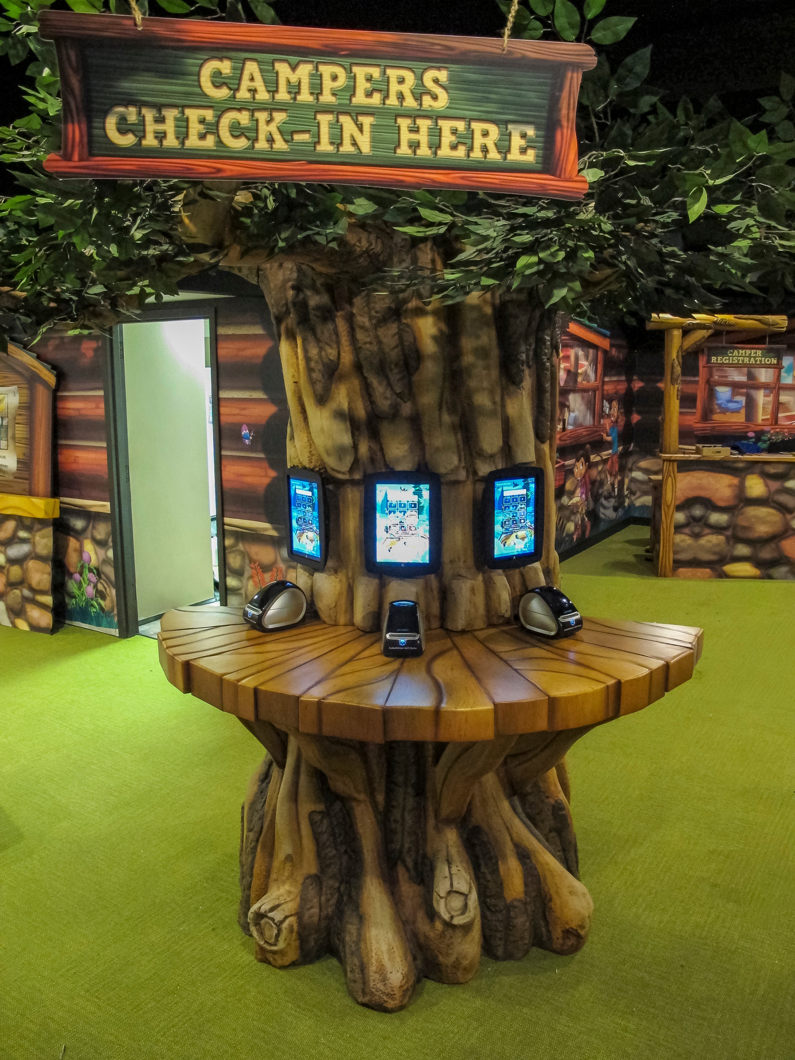Custom Campers Check-In station with integrated touchscreen kiosks in Faith Community Church's camp-themed FaithKids children's ministry.