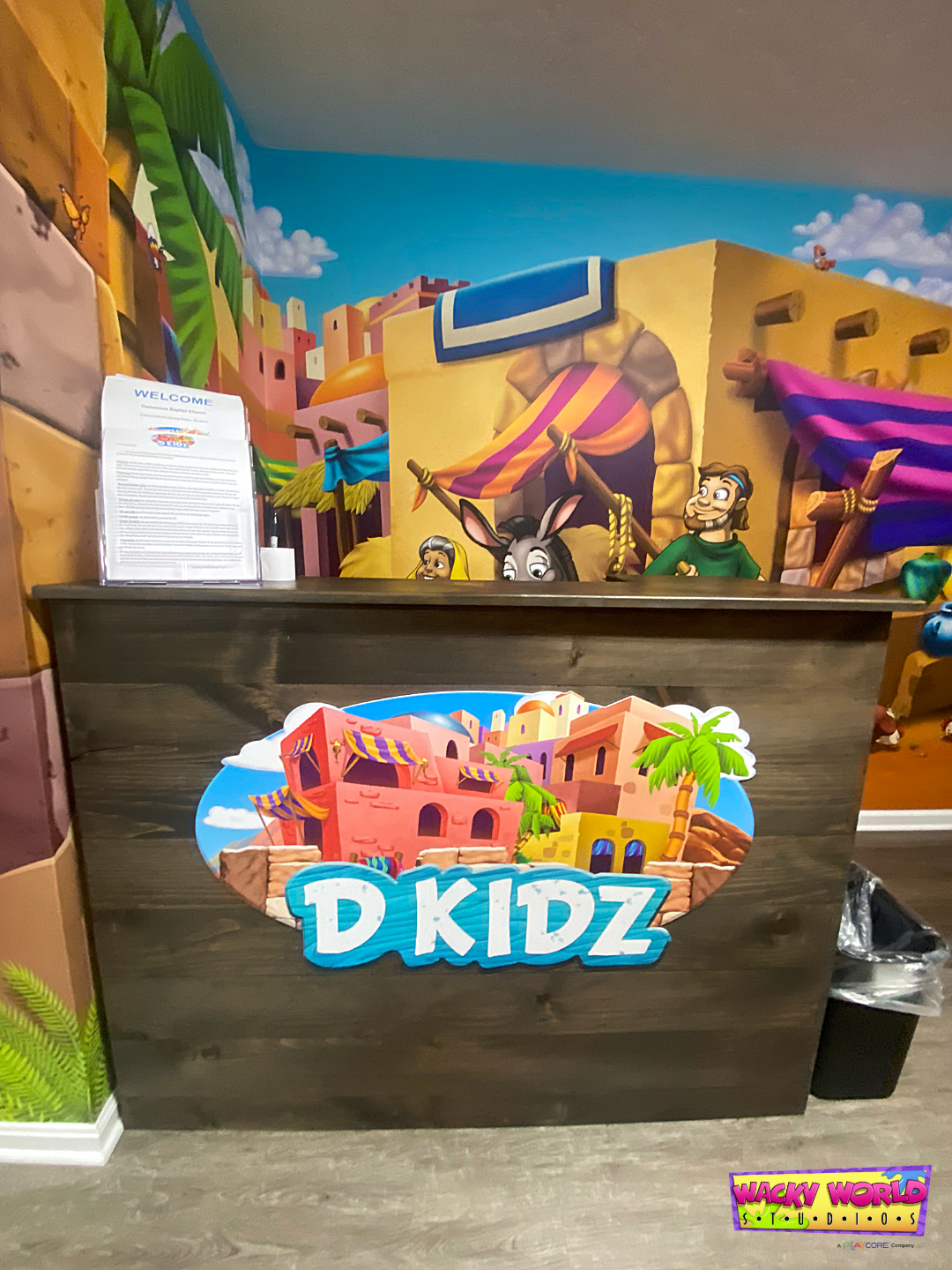 Custom D Kidz children's ministry logo and branded check-in desk at Damascus Baptist Church