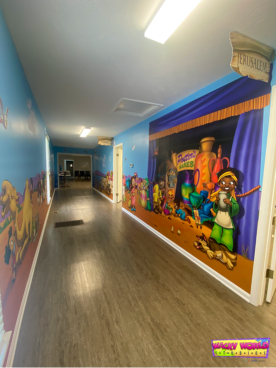 Biblical marketplace street mural with merchants and storefronts in a church children's ministry space