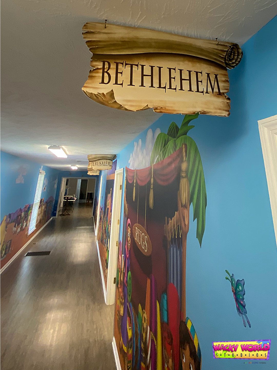 Bible-times marketplace murals and themed wayfinding signs in a children's ministry hallway at Damascus Baptist Church