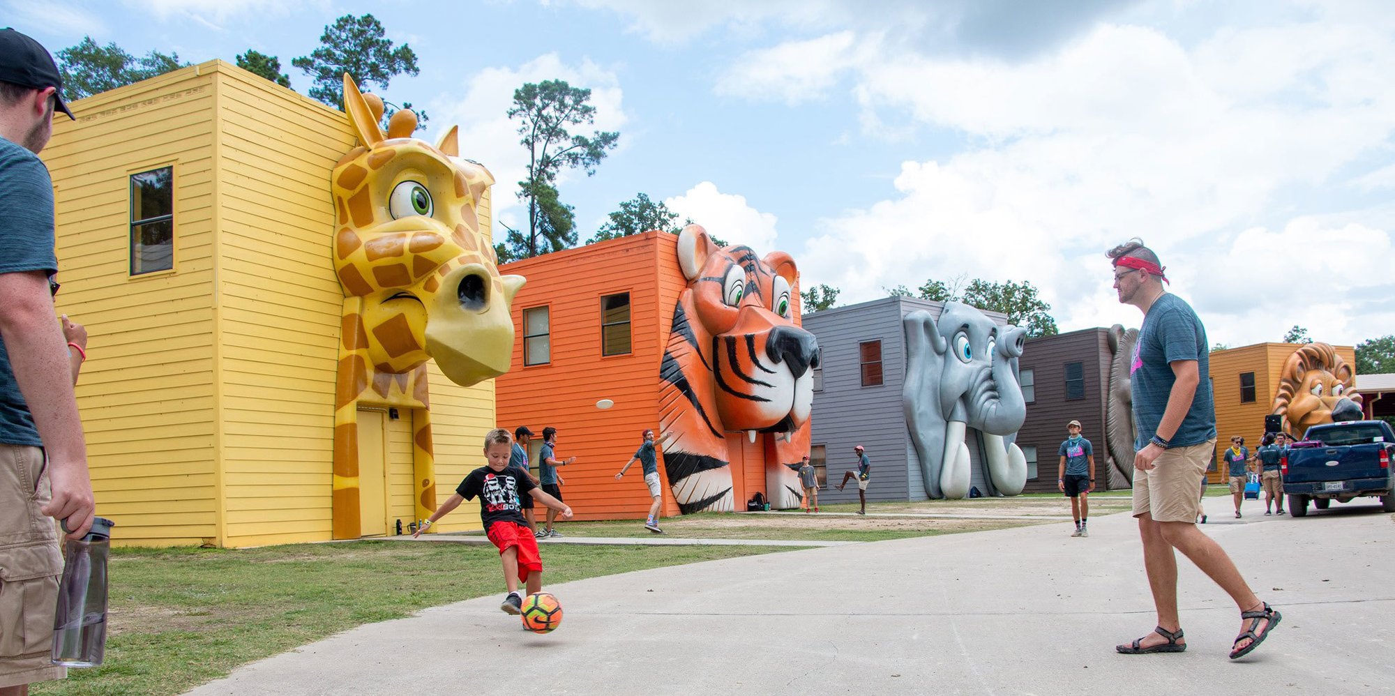 Kids and Parents Playing Outside Giant Animal Face Facade Camp Cabins at Carolina Creek Christian Camp