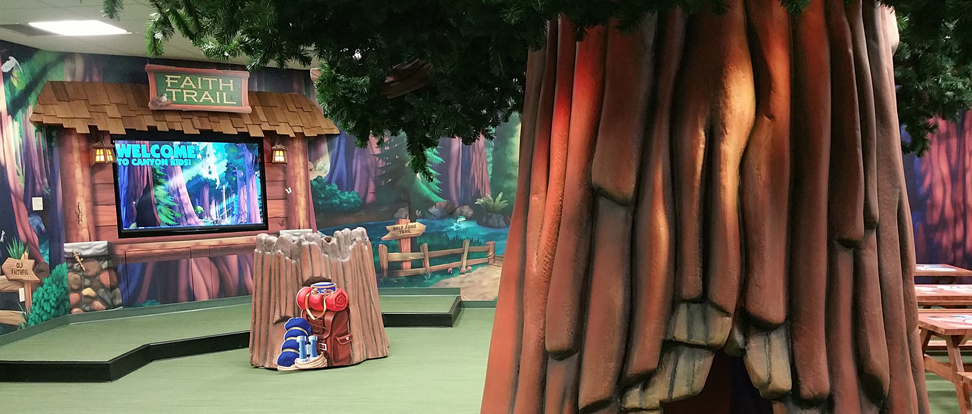 3D sculpted tree, lodge facade and forest murals in a Camping Themed Space at Faith Family Church