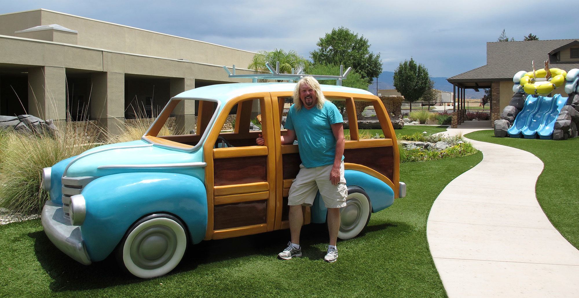 Bruce Barry in front of a life size Woody wagon outdoor play feature at a Camping Themed Environment at Canyon Hills Church