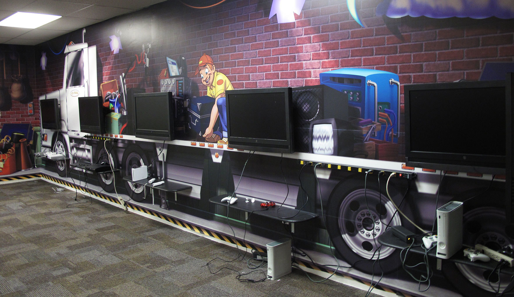 Delivery Truck Themed 5-display Gaming Stations with brick wall background mural at Victory Church TX