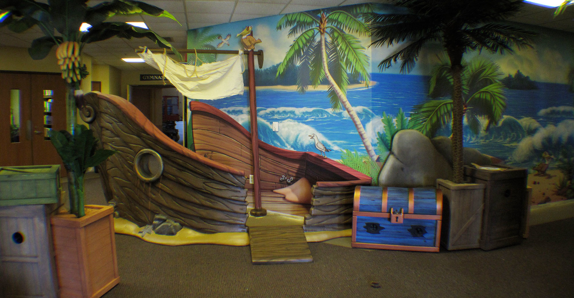 3D sculpted shipwreck, crates, treasure chest and tree plus full murla of jungle beach scene in a Jungle Themed Area at FUMC Springfield
