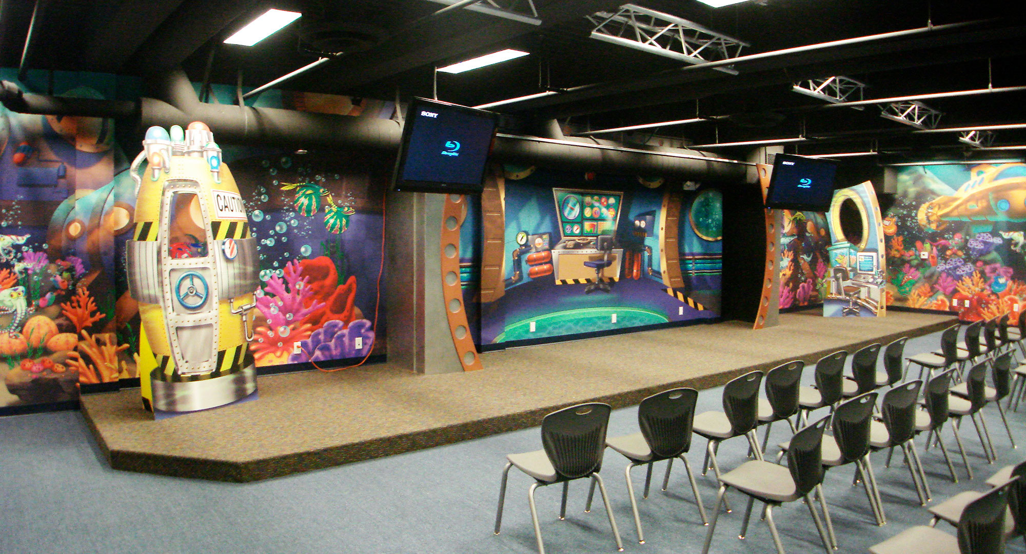Undersea Themed Stage with 2D Cutouts of airlock and control console plus full wall murals behind.