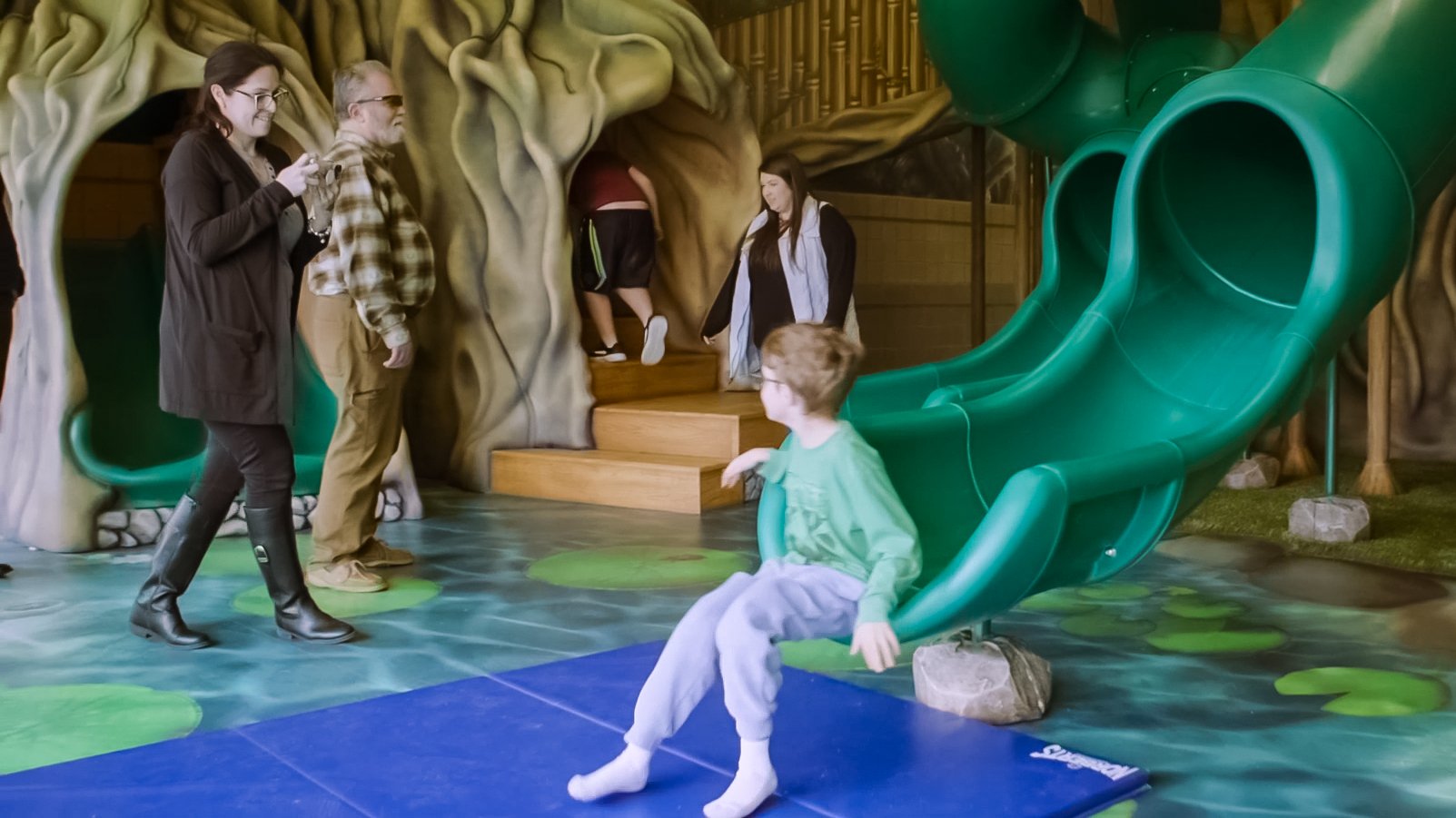 Families enjoying an immersive indoor treehouse environment designed to encourage shared play, family engagement, and meaningful experiences together.