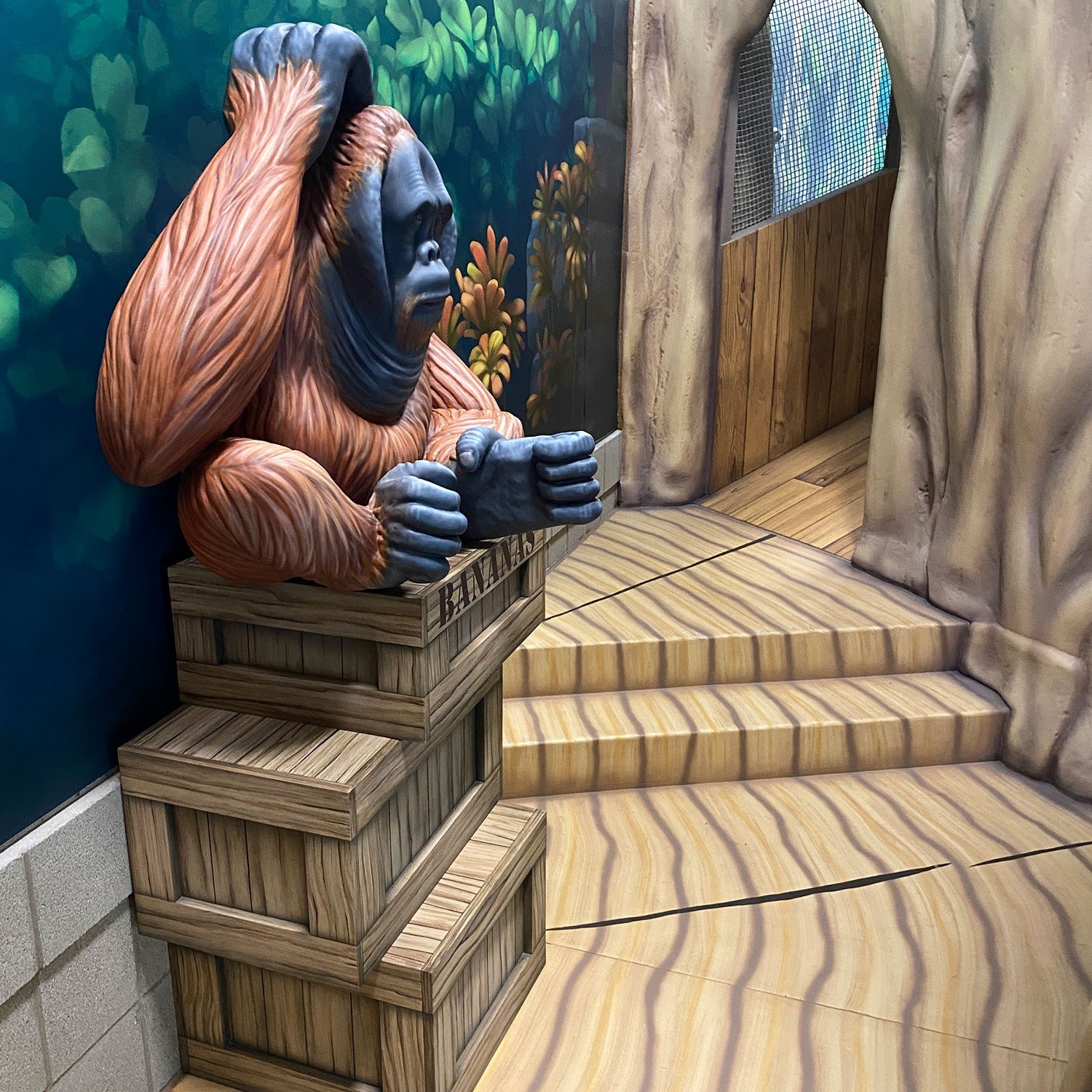 3D sculpted Orangutan atop crates and wooden walkway at West Chicago Park District Treetop Escape themed environment