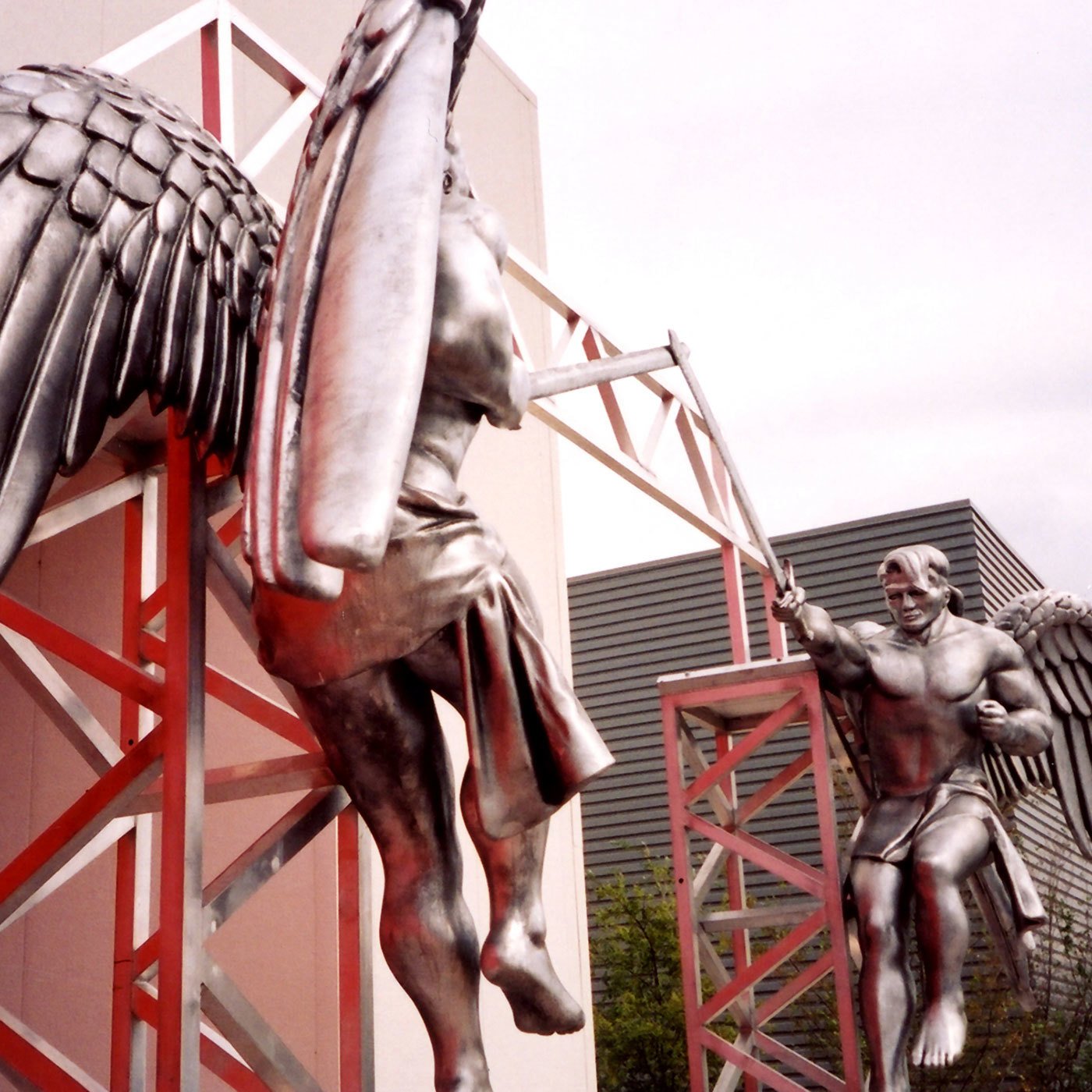 Outdoor 3D Sculpted Angels made of foam but painted to look like metal, mounted on an aluminum truss at the entrance of a church.