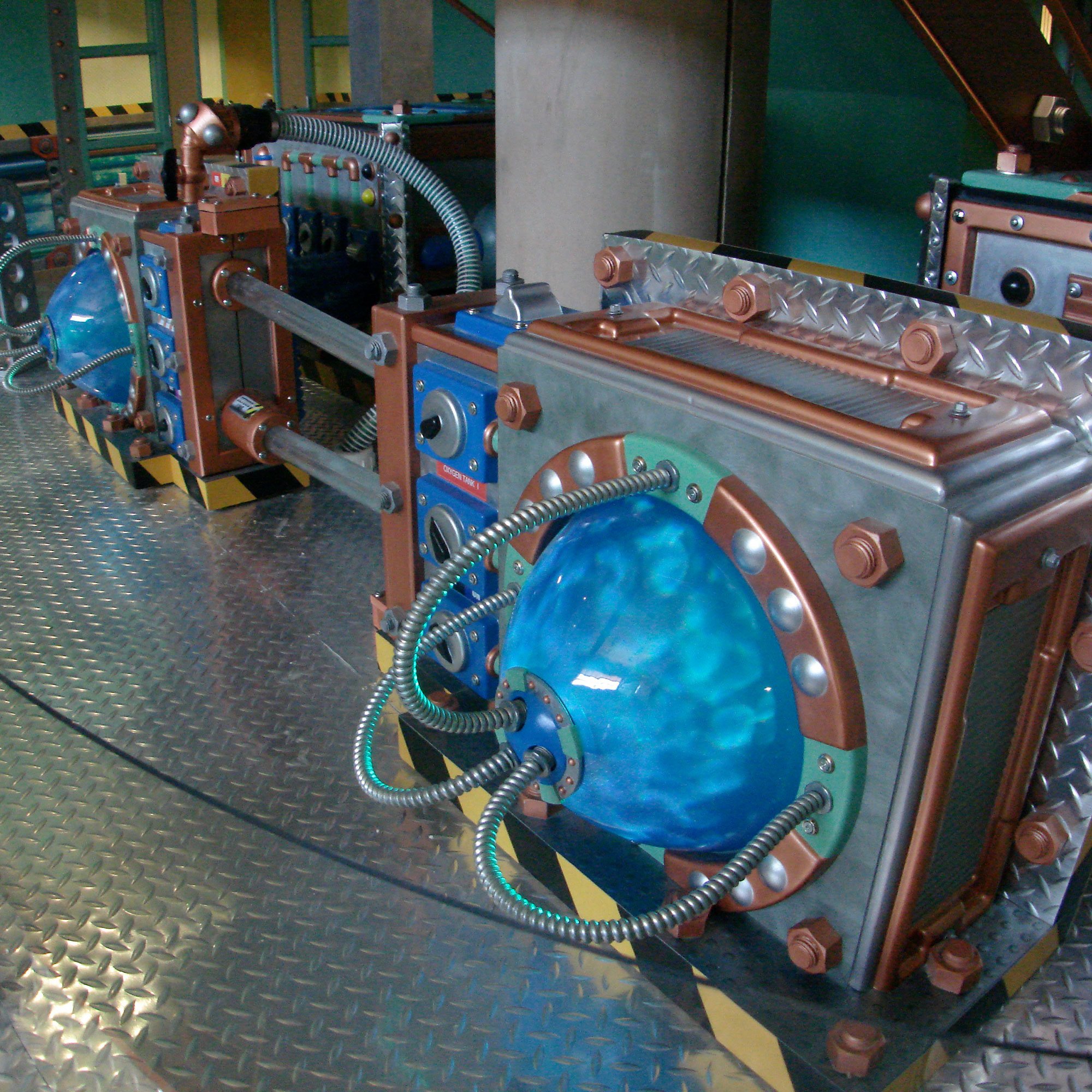 Custom designed Science Lab 3D Sculpted Props with copper clad silver boxes and aluminum tubing on a diamond plate flooring.