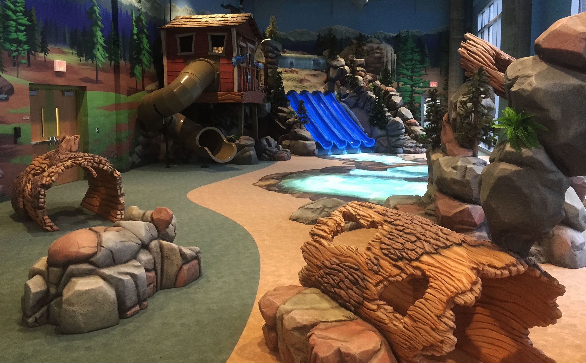 Sculpted fallen logs and rocksplus ranger station and slides in a Fully Immersive Camping Themed Environment at Abundant Life Church