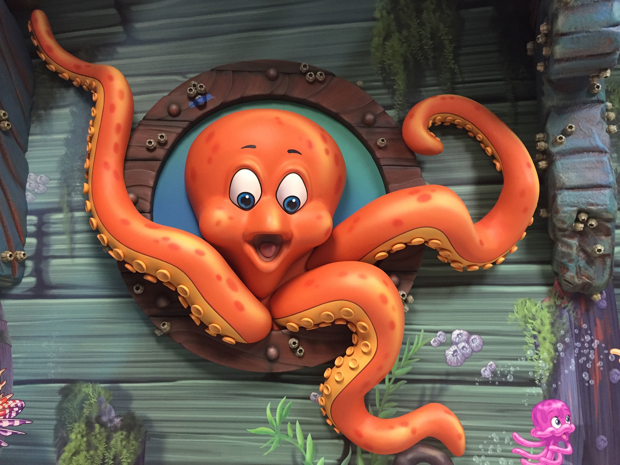 3D relief sculpted Octopus in a porthole plus sunken ship murals in an Undersea Themed Space at America's ER