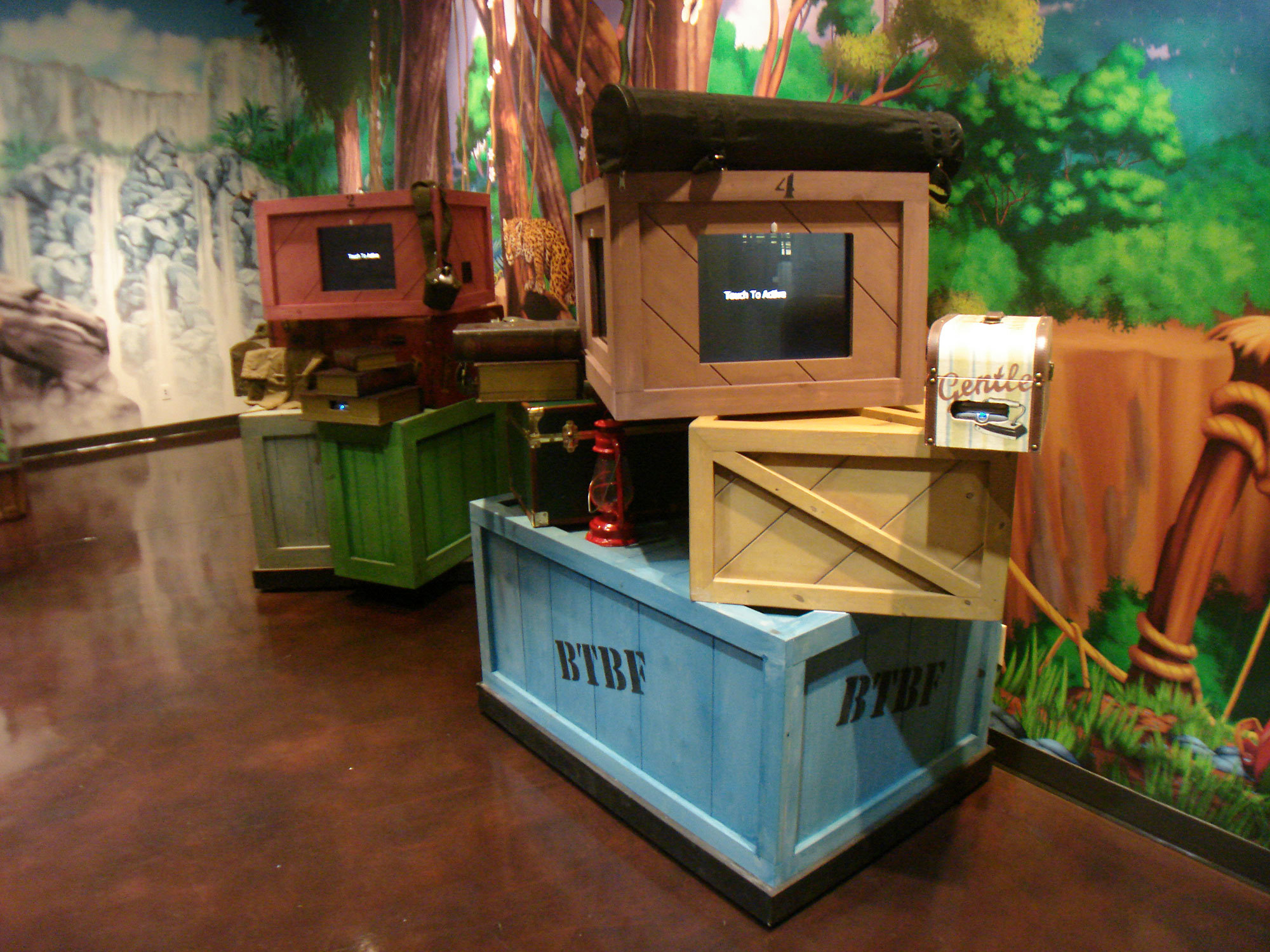 3D crates, books and lamps as a check-in station in a Jungle themed space at Bent Tree Fellowship Church.