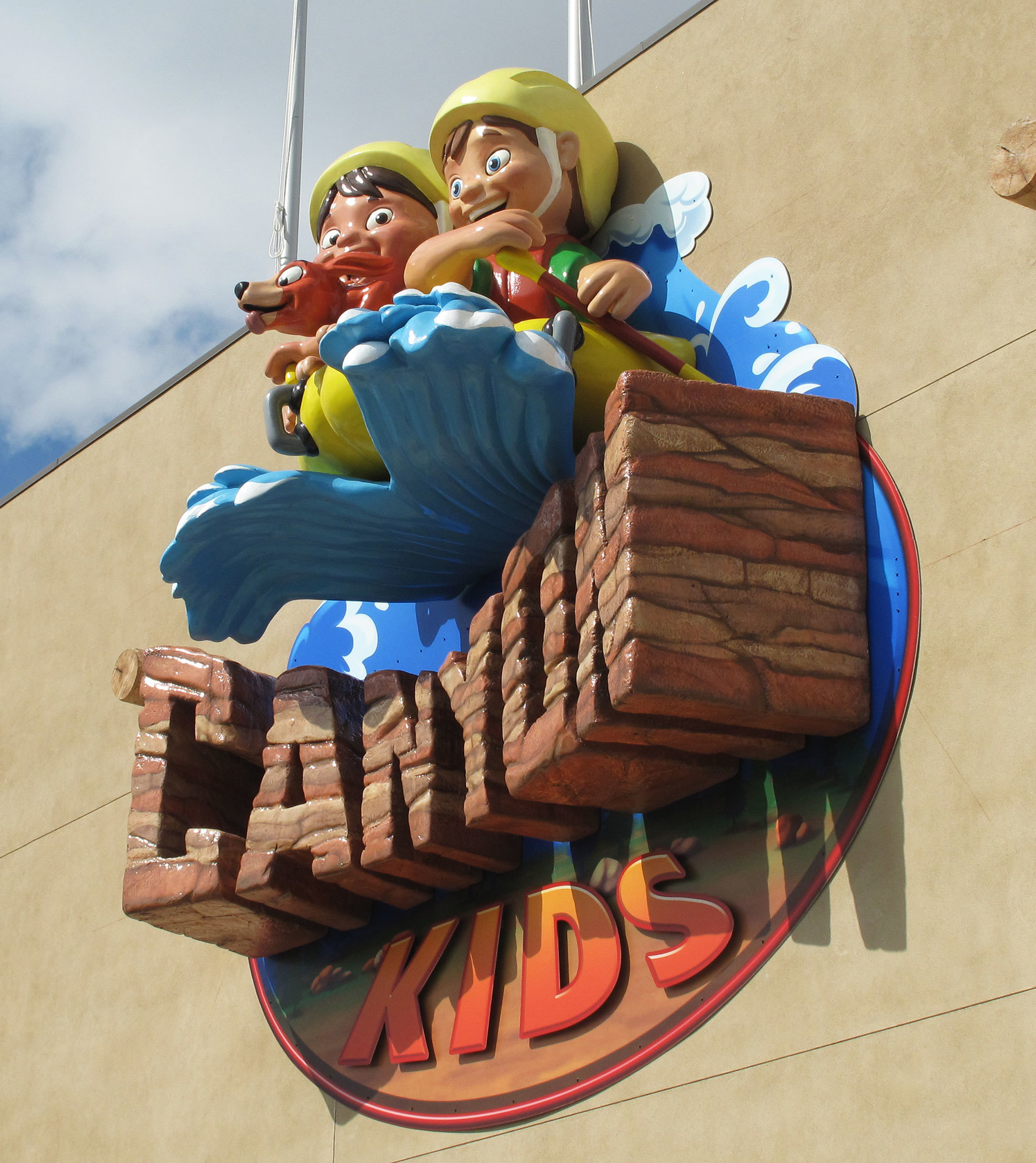 3D relief sculpted sign with 2 kids in a raft above the words "Canyon Kids" as a sign high on an exterior wall of a church