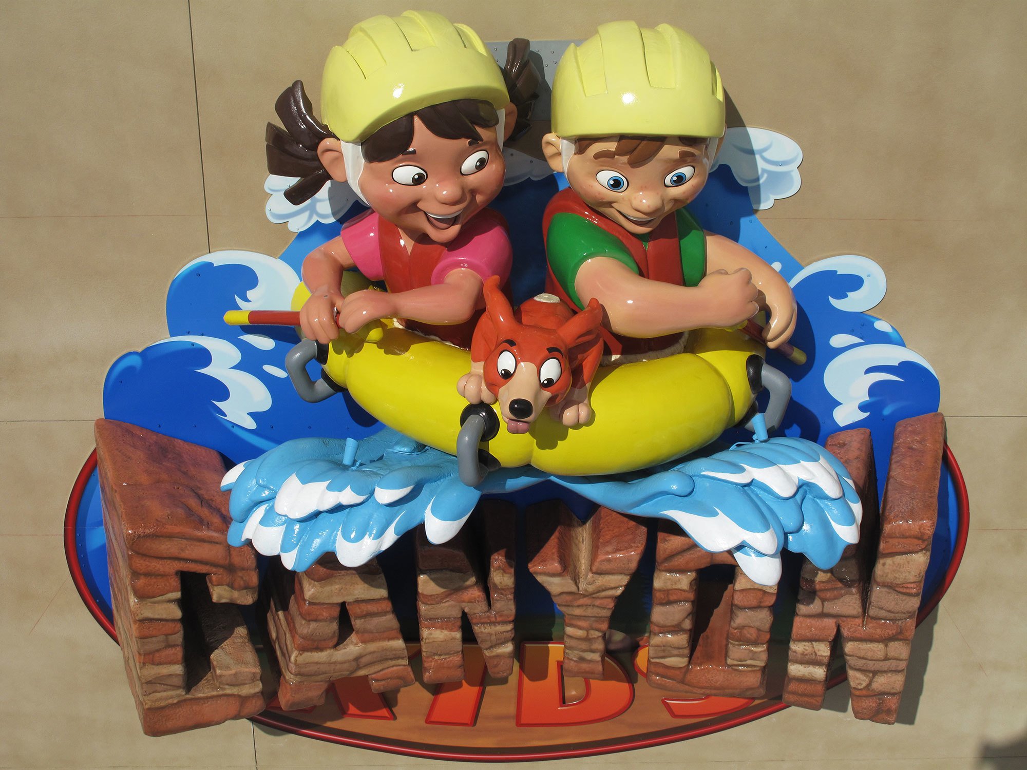 3D relief sculpted sign with 2 kids in a raft above the words "Canyon Kids" as a sign high on an exterior wall of a church