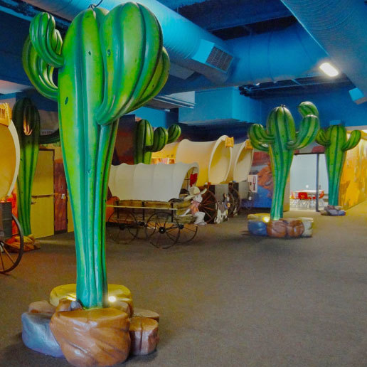 3D cacti and covered wagon check in desks in a Western Themed Space at Crossroads Church