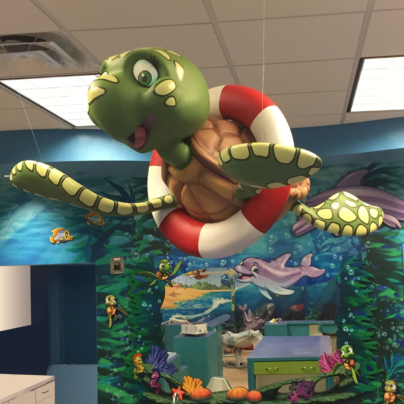 3D Sculpted Turtle with life preserver hanging in a Beach and Undersea Theme at Gulfshore Pediatric