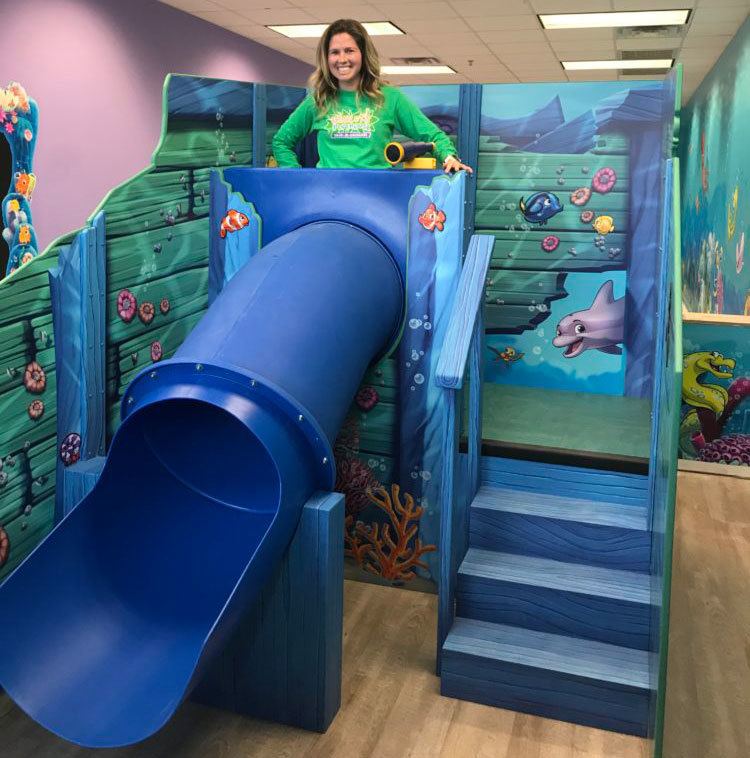Blue slide and staircase in a 2D cutout sunken ship play feature in an Undersea Themed Environment at Ashley's Playhouse