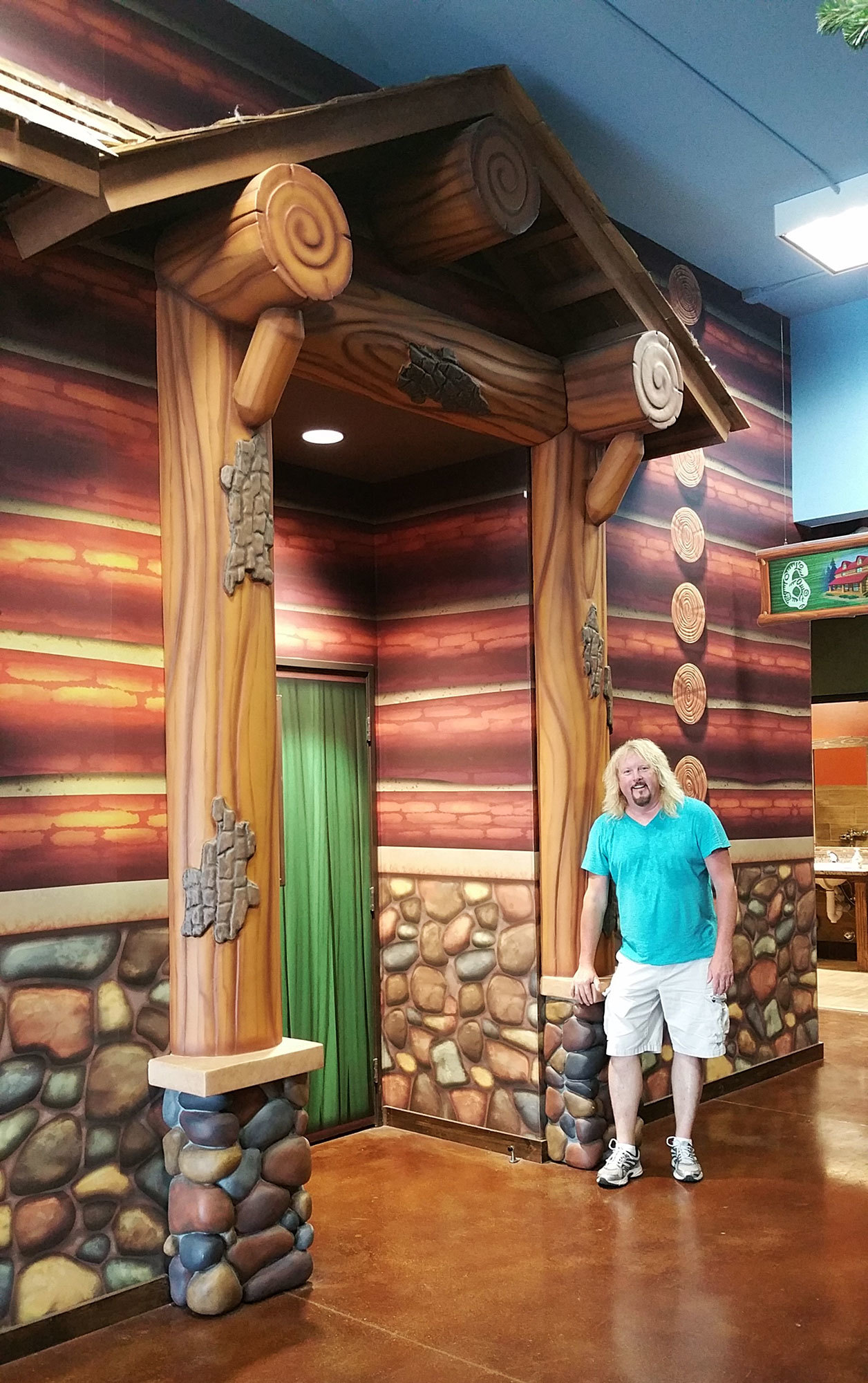 Bruce Barry in front of a log cabin Camping Lodge Facade at Canyon Hills Church