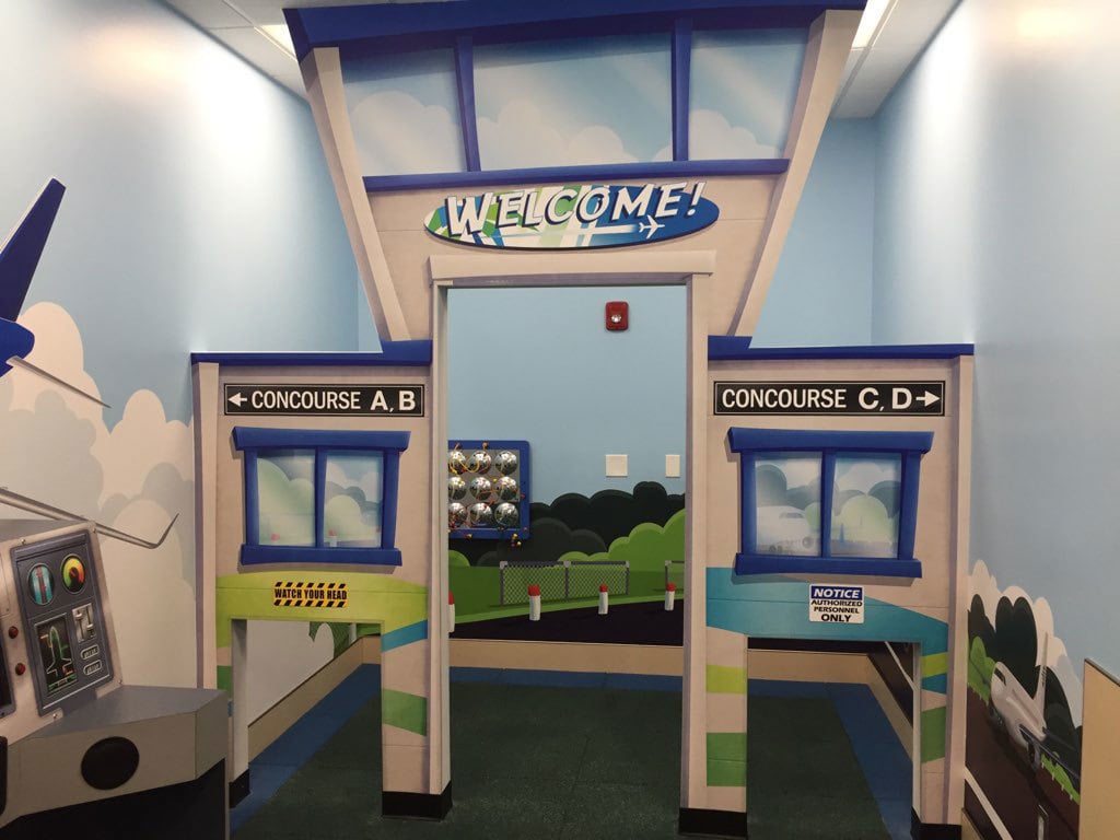 2D facade of control tower and concourse gates plus wall murals of airport runway in a Clearwater Airport Play Area