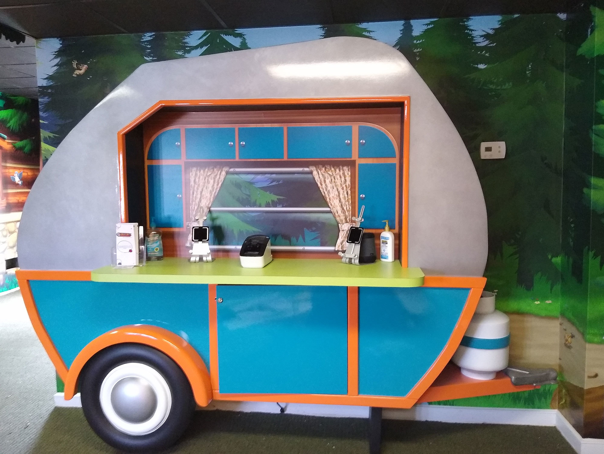 Camping Themed Check-In Kiosk designed as a life-size blue and silver vintage travel trailer