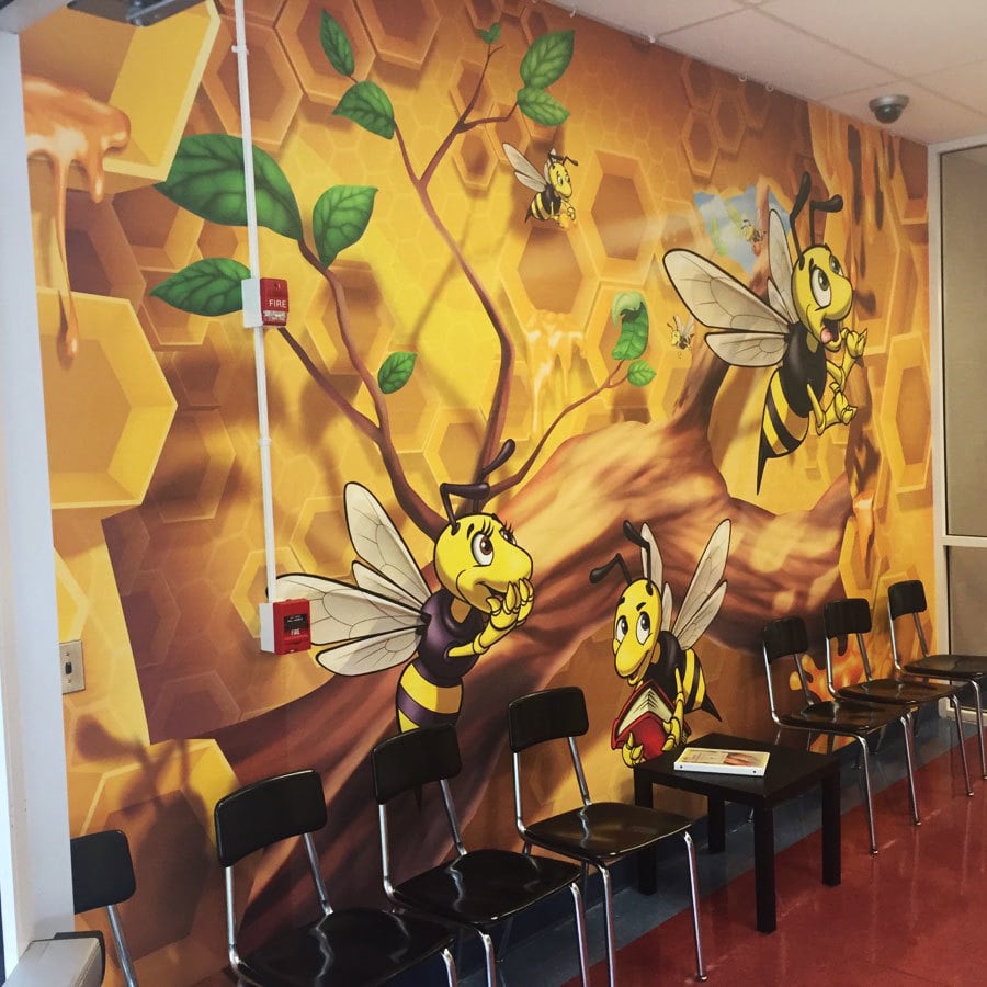 Wall mural with honeycomb and bee characters.