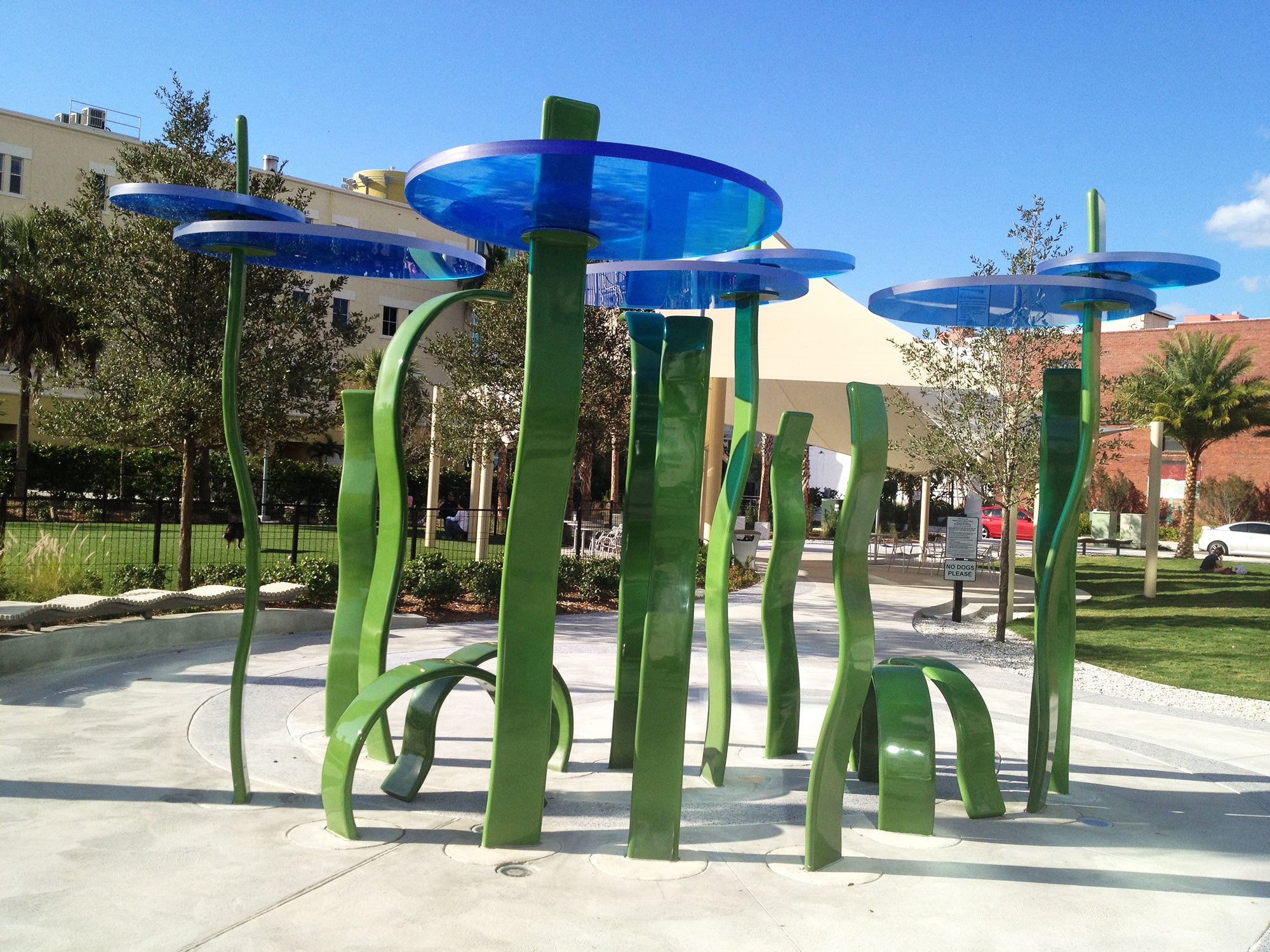 Community Art Installation in Florida with green ribbon-like wavy poles topped with blue acrylic discs.